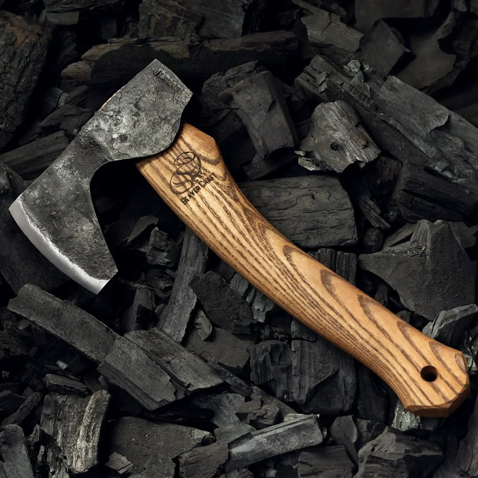 Beavercraft Compact Long-Bearded Bushcraft Hatchet on a bed of charcoal pieces