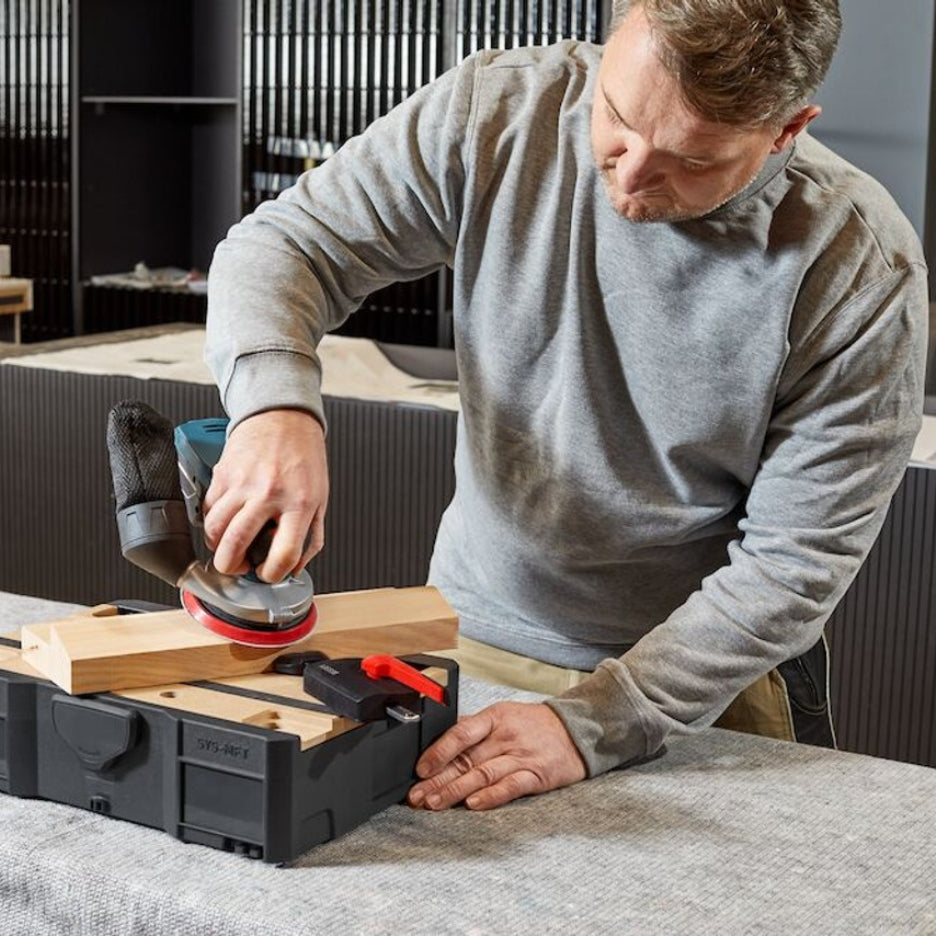 Man sanding work being held with Bessey Tools Horizontal Table Clamp Fixture