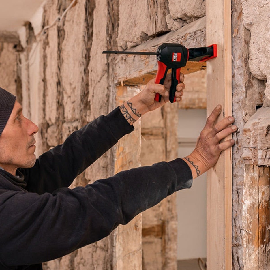 Man holding wood frame and clamping it with Bessey Tools Large Trigger Clamps