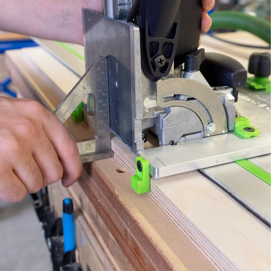 Hand holding precision triangle close to Domino Joiner and FastCap Domino Joiner Sled