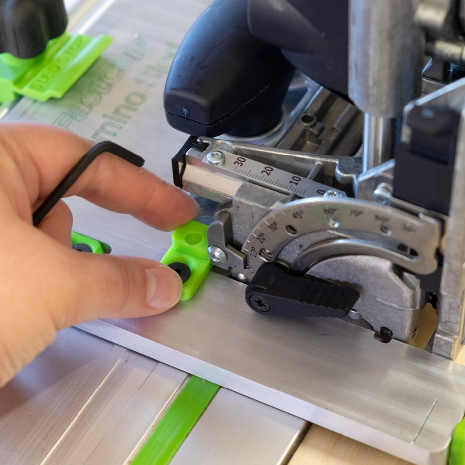 Hand holding Fastcap Domino Sled green tab