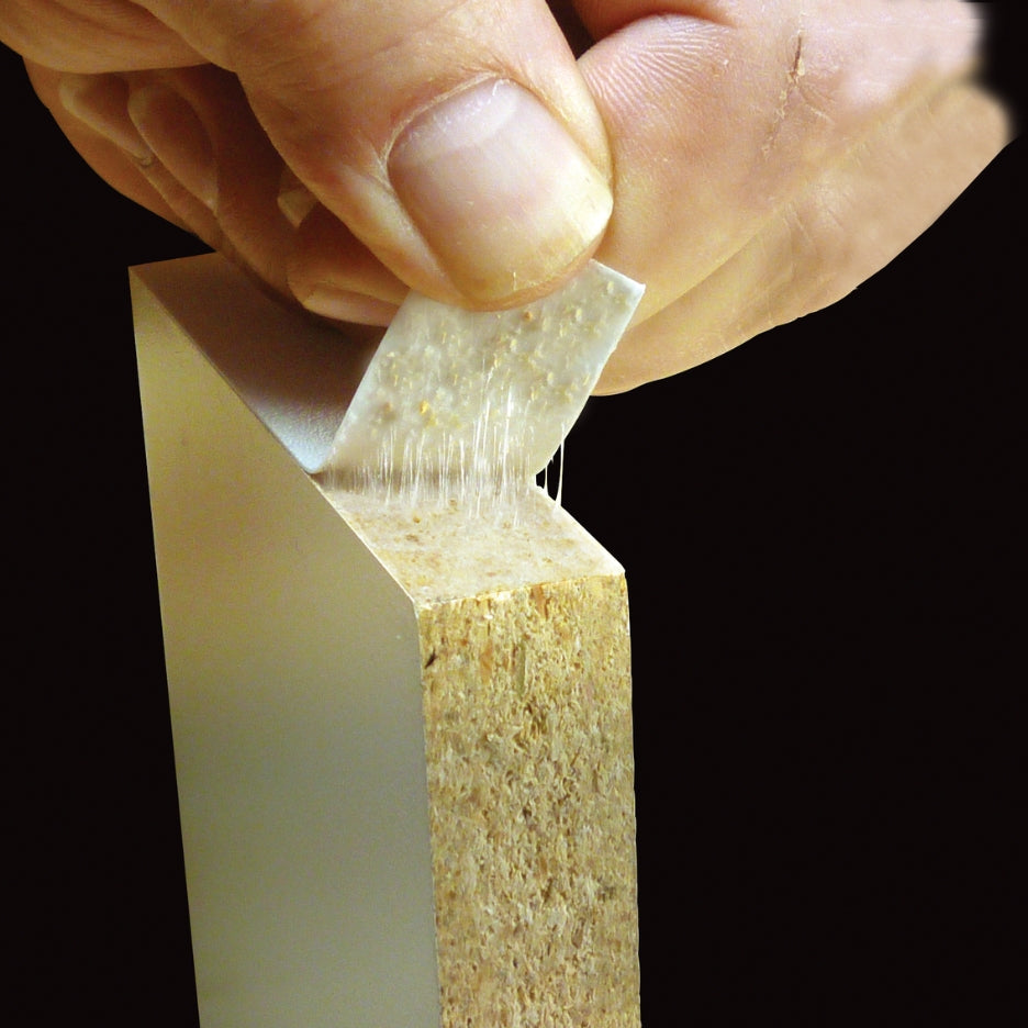Hand pulling FastCap Fastedge from wood