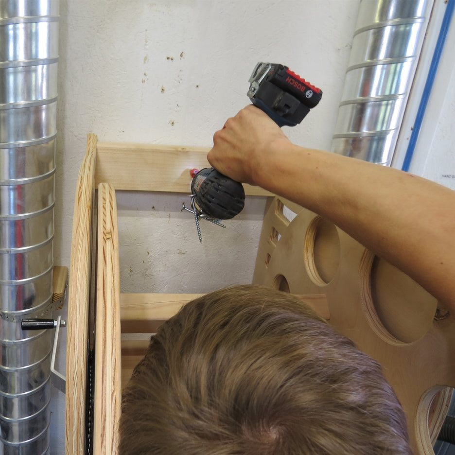 Person screwing Fastcap SUPER REEL to wall