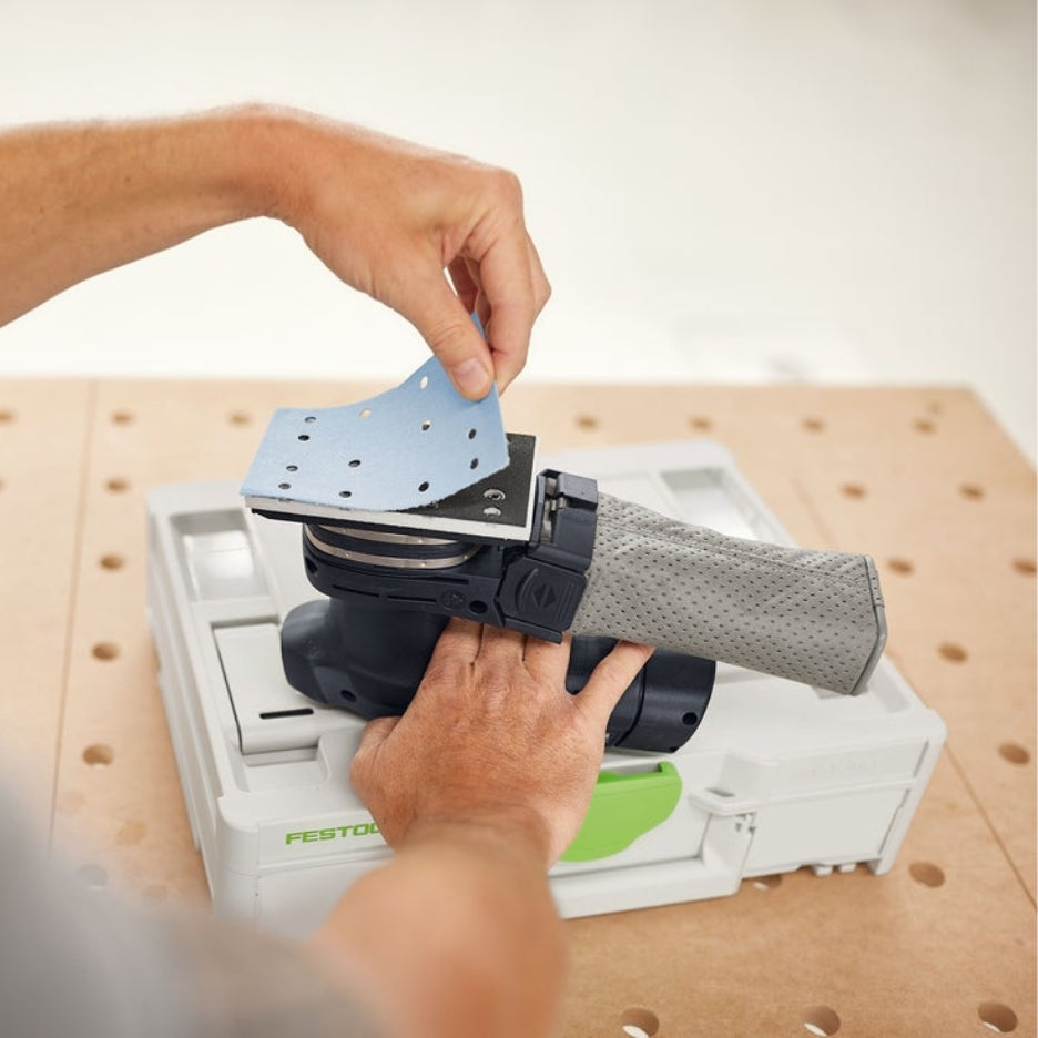 Hands removing Granat abrasive from sander