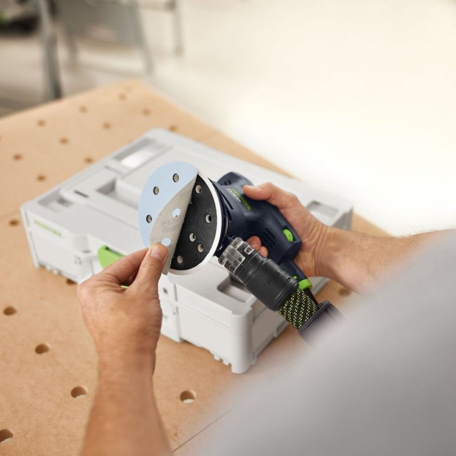 Hands removing Granat abrasive disc from sander