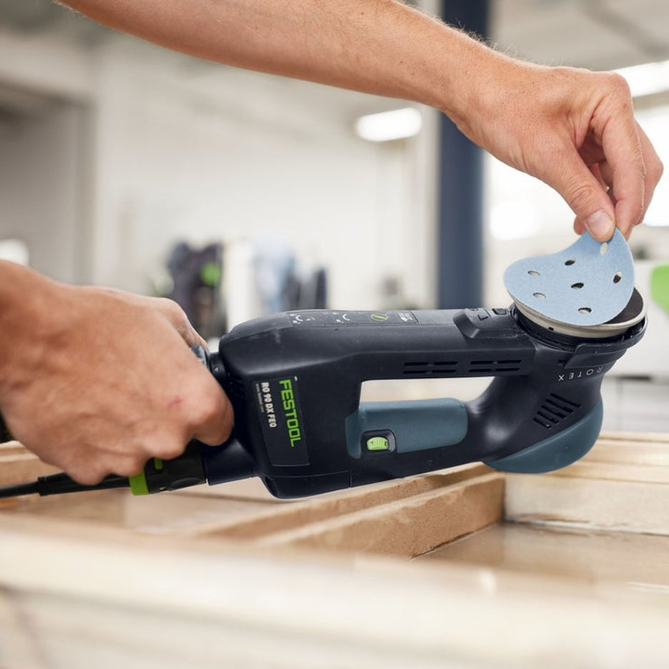 Hands removing Granat abrasive disc from sander