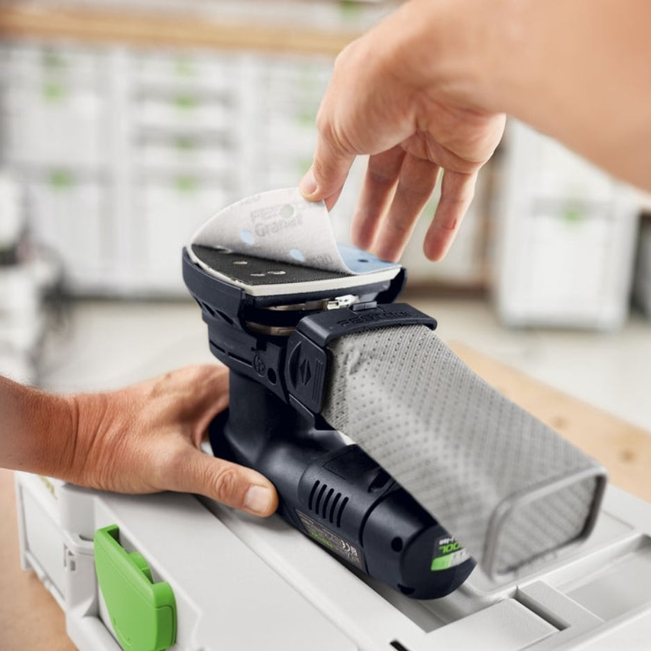 Hands removing Granat delta abrasive from sander