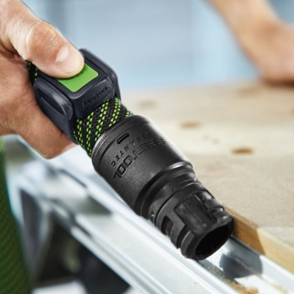 Hand holding Festool remote control attached to dust extractor hose