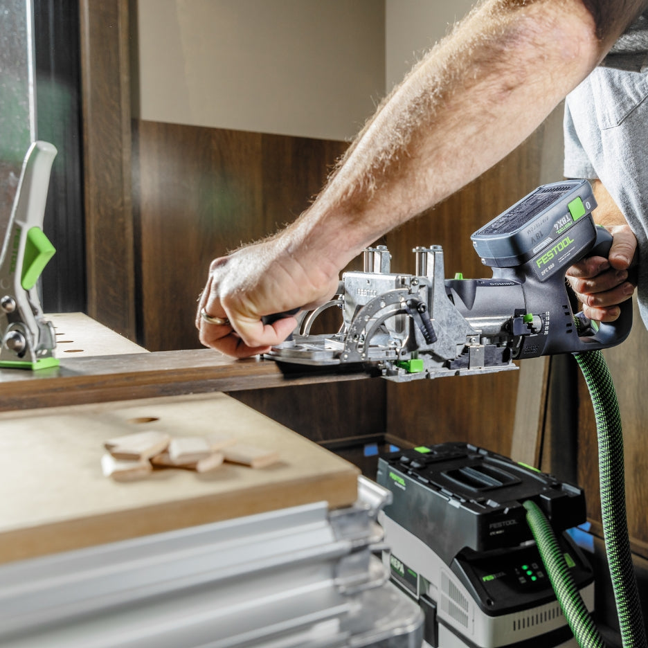 Person using Festool Cordless Domino Joiner DFC 500 attached to a dust extractor