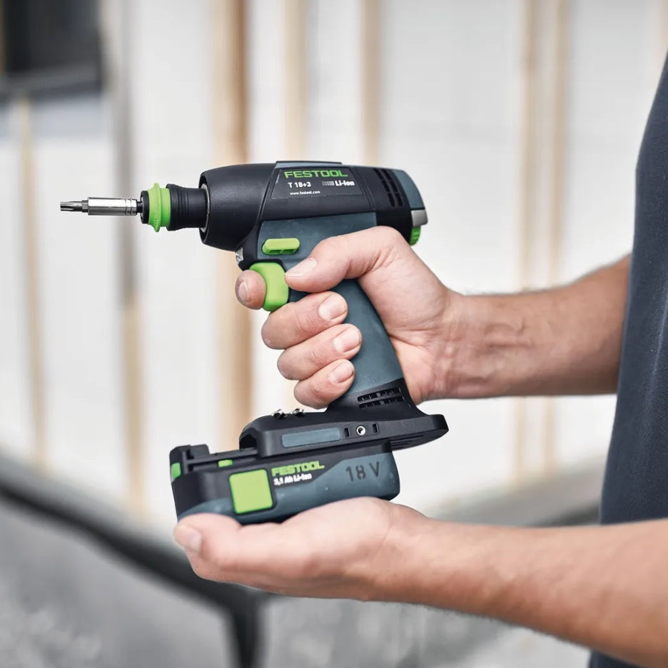 Person holding Festool Cordless Drill T 18+3 and battery pack with a blurred background