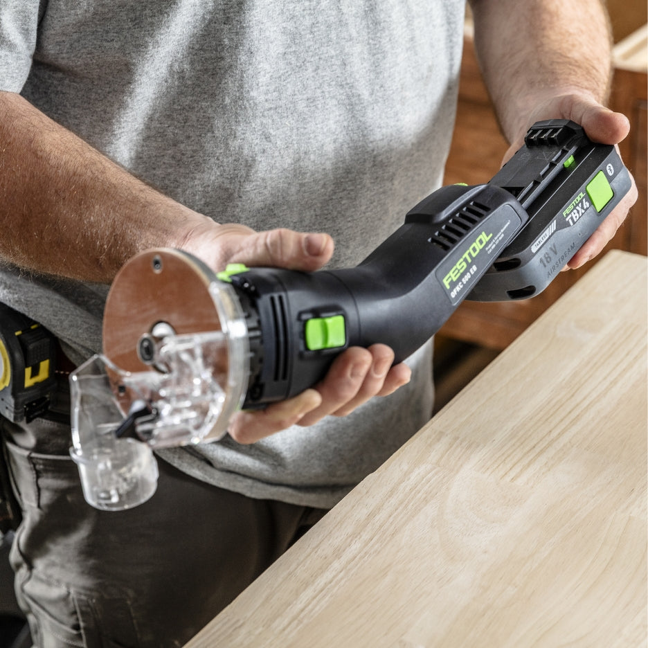 Person attaching battery to Festool Cordless Edge Trimming Router OFKC 500 R3 EB-Basic