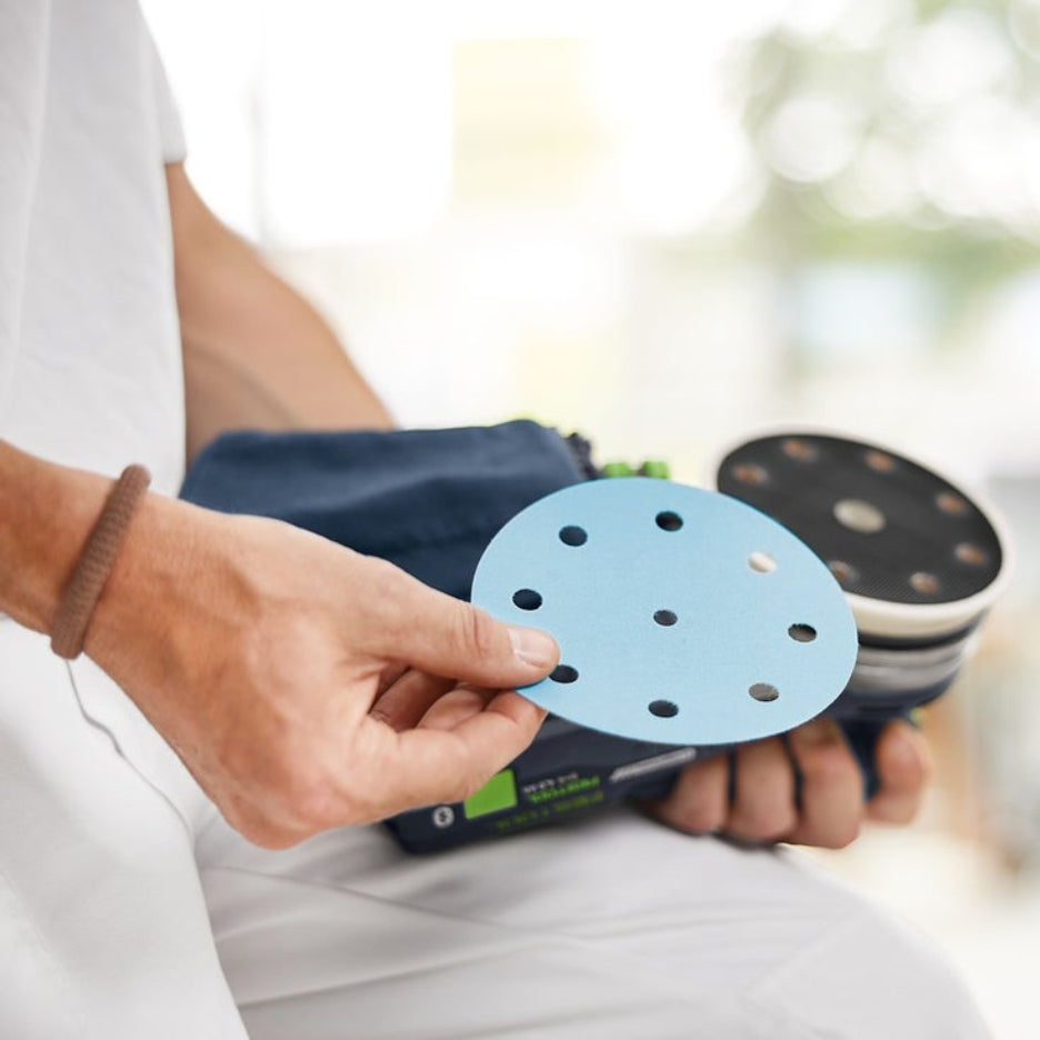 hands holding Festool ETSC 2 125 and Granat abrasive disk