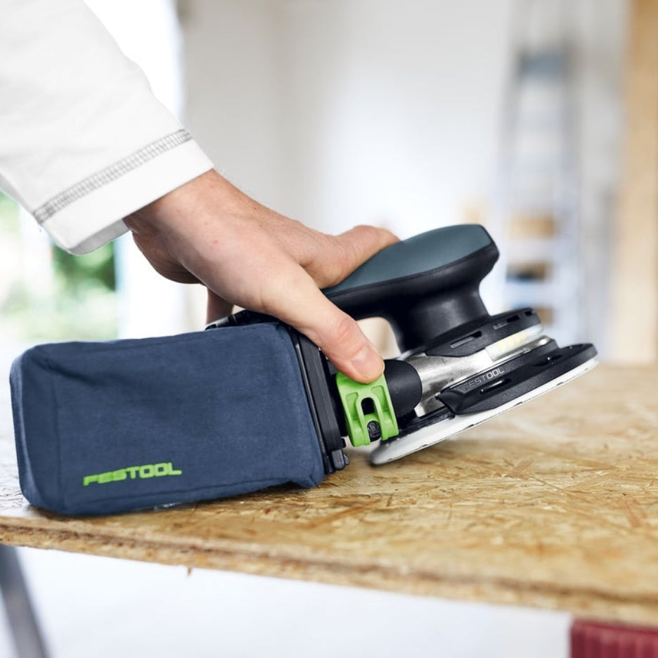 Hand holding Festool ETSC 2 150 with dust bag attached to it
