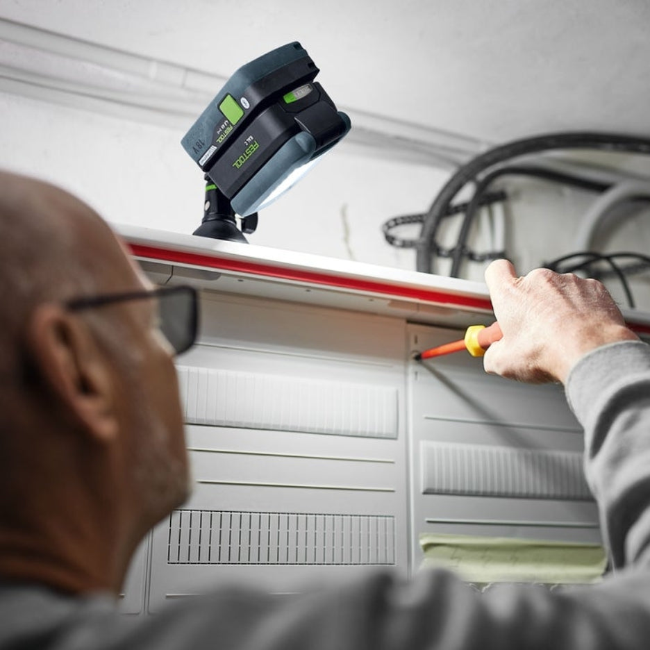 Man using Festool Cordless Task Light SYSLITE KAL C to illuminate electrical panel door