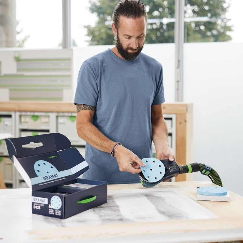Man placing Festool Granat 5 Inch Abrasive Disc in sander
