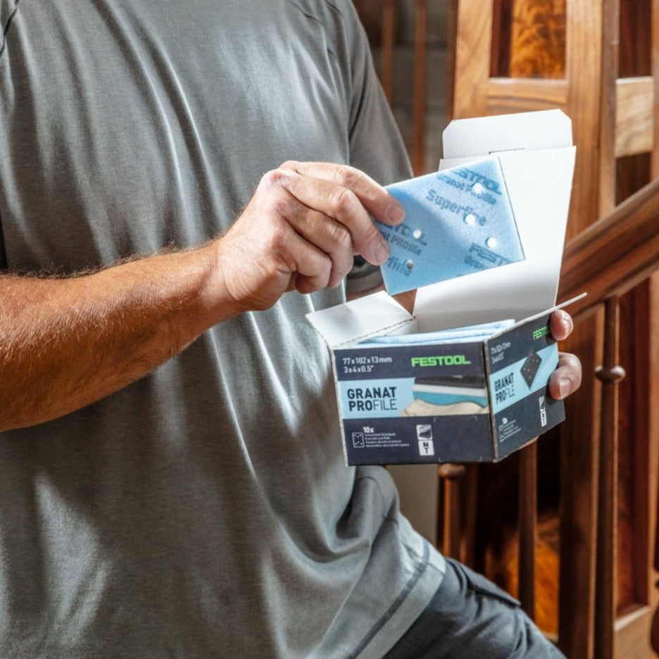 Man holding box of Festool Grit Abrasives Granat PROfile 3x4 M GR PRO