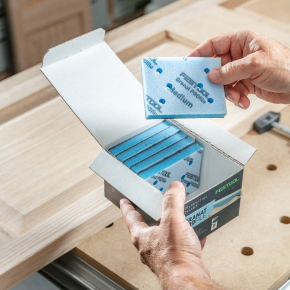 Hands holding Festool Grit Abrasives Granat PROfile 3x4 M GR PRO and box