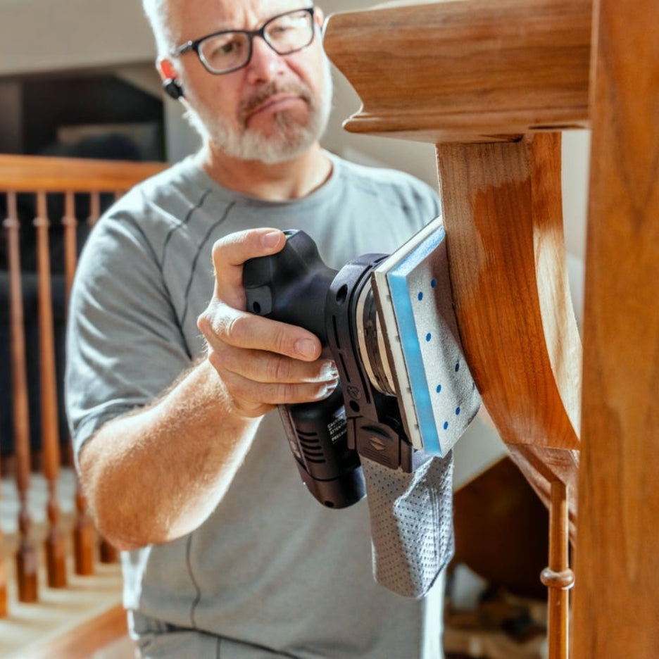Person using Festool sander with Festool Grit Abrasives Granat PROfile 80x133 M GR PRO to sand a staircase railing