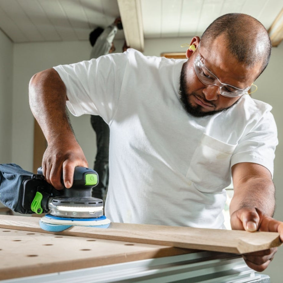 Man sanding a piece of wood using a Festool sander and Festool Grit Abrasives Granat PROfile D150 M GR PRO
