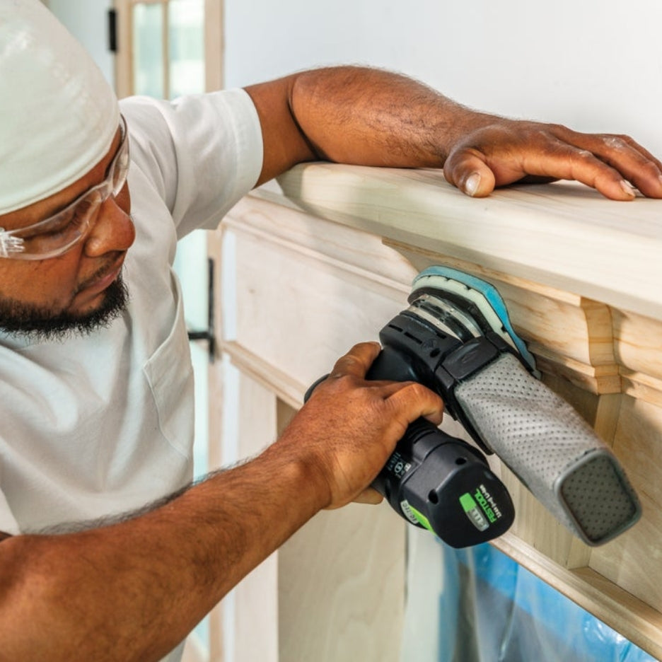 Man sanding fireplace mantel using cordless Festool sander with Festool Grit Abrasives Granat PROfile Delta M GR PRO