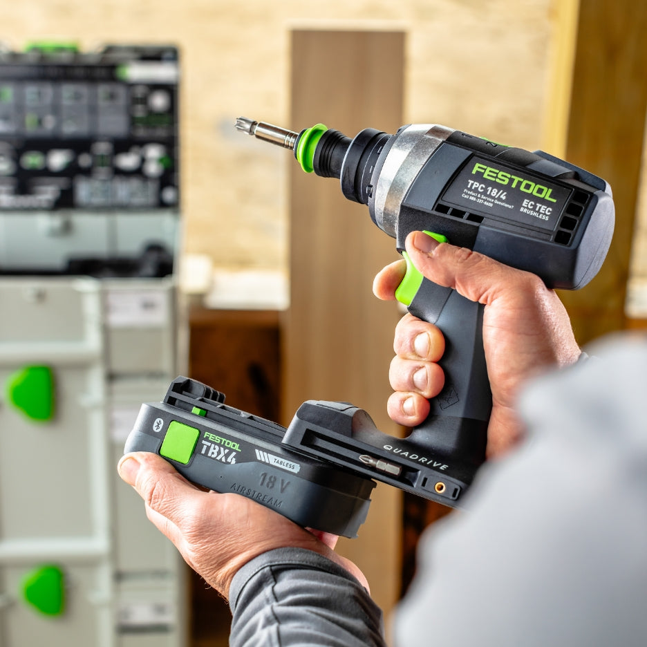 Hands holding Festool Percussion Drill and inserting battery