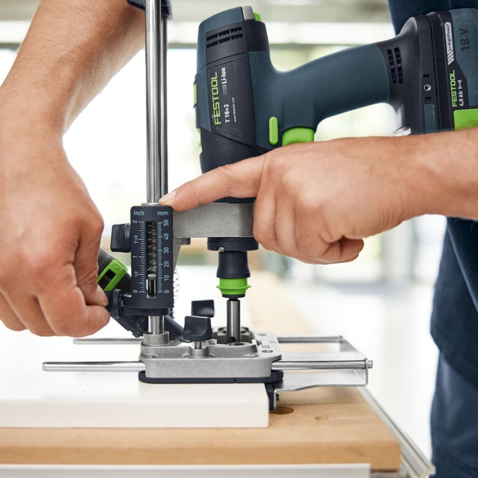 Person adjusting height of the Festool Mobile Drilling Attachment MB 40 attached to a drill