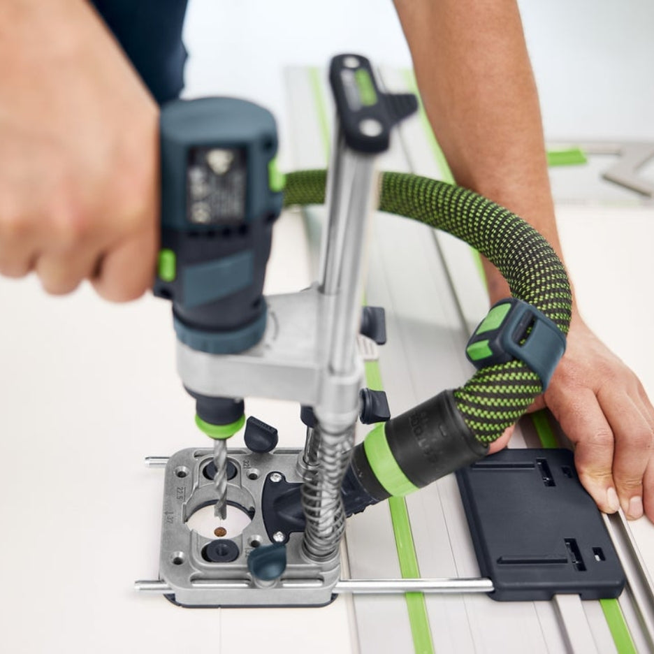 Person using Festool Mobile Drilling Attachment MB 40 attached to drill and dust extractor on a guide rail