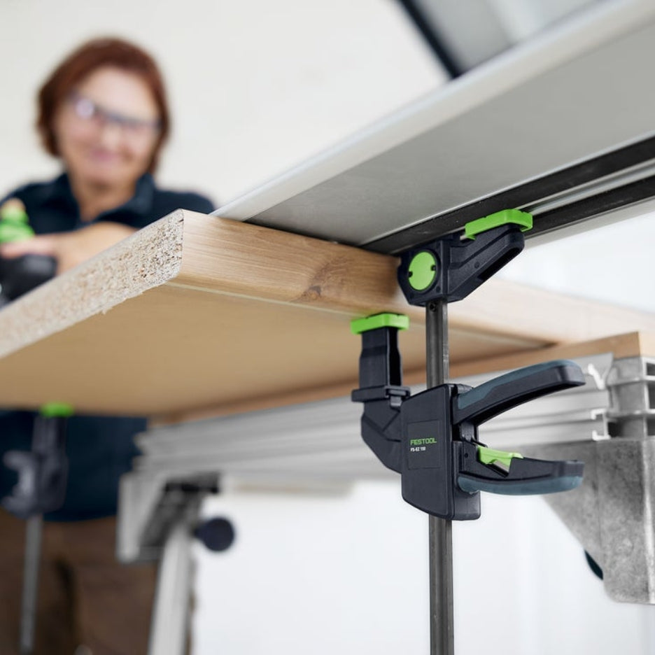 Person using Festool One-Handed Clamp FS-EZ 150 on a piece of wood with a blurred background