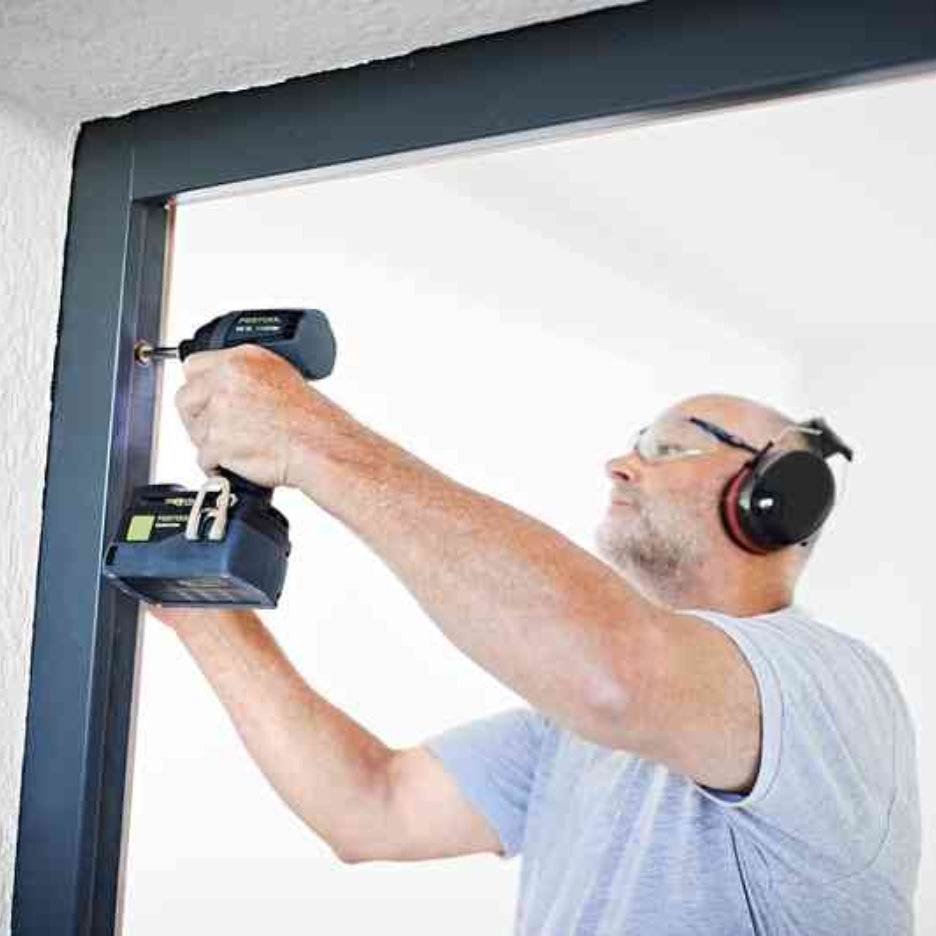 Man using Festool TID 18 cordless impact screwdriver on window frame