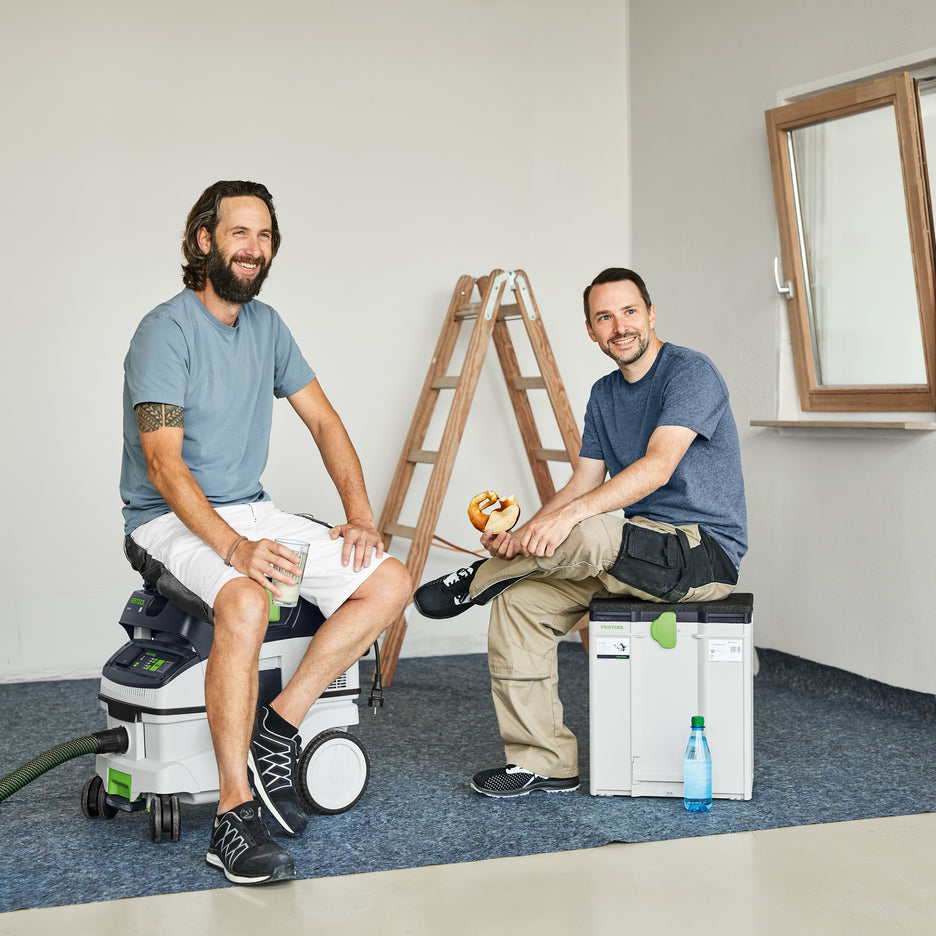 Two workers take a break and relax on Festool Seat Cushions on a dust extractor and Systainer. It's easy to make seats of different heights with the modular design.