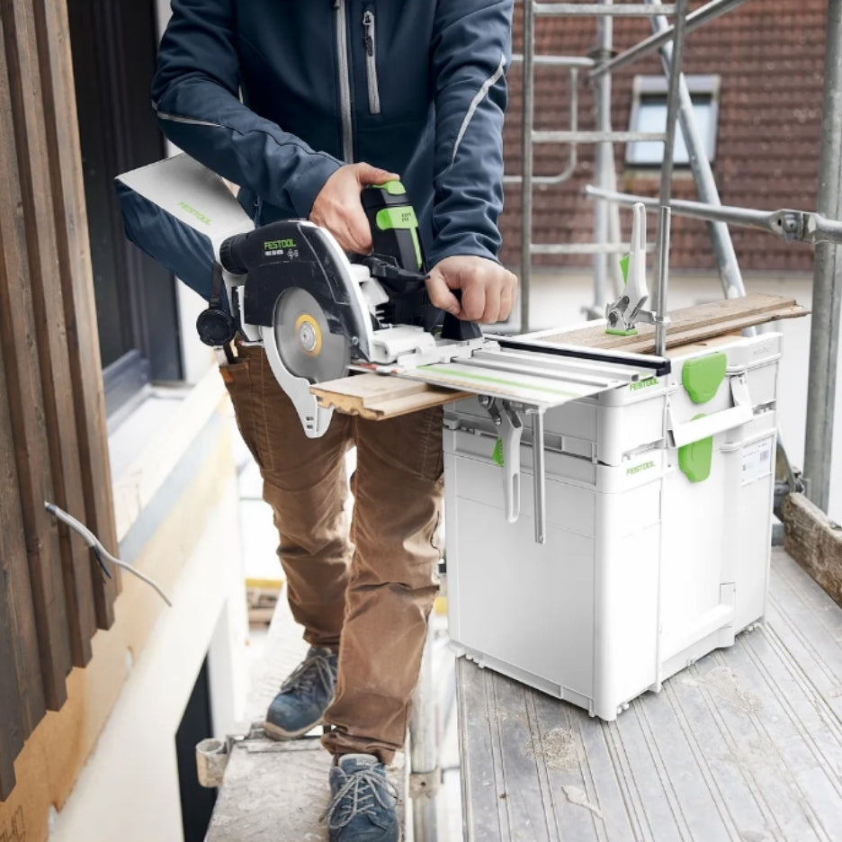 Person using a Festool track saw to cup a piece of wood on top of a stack of Systainers