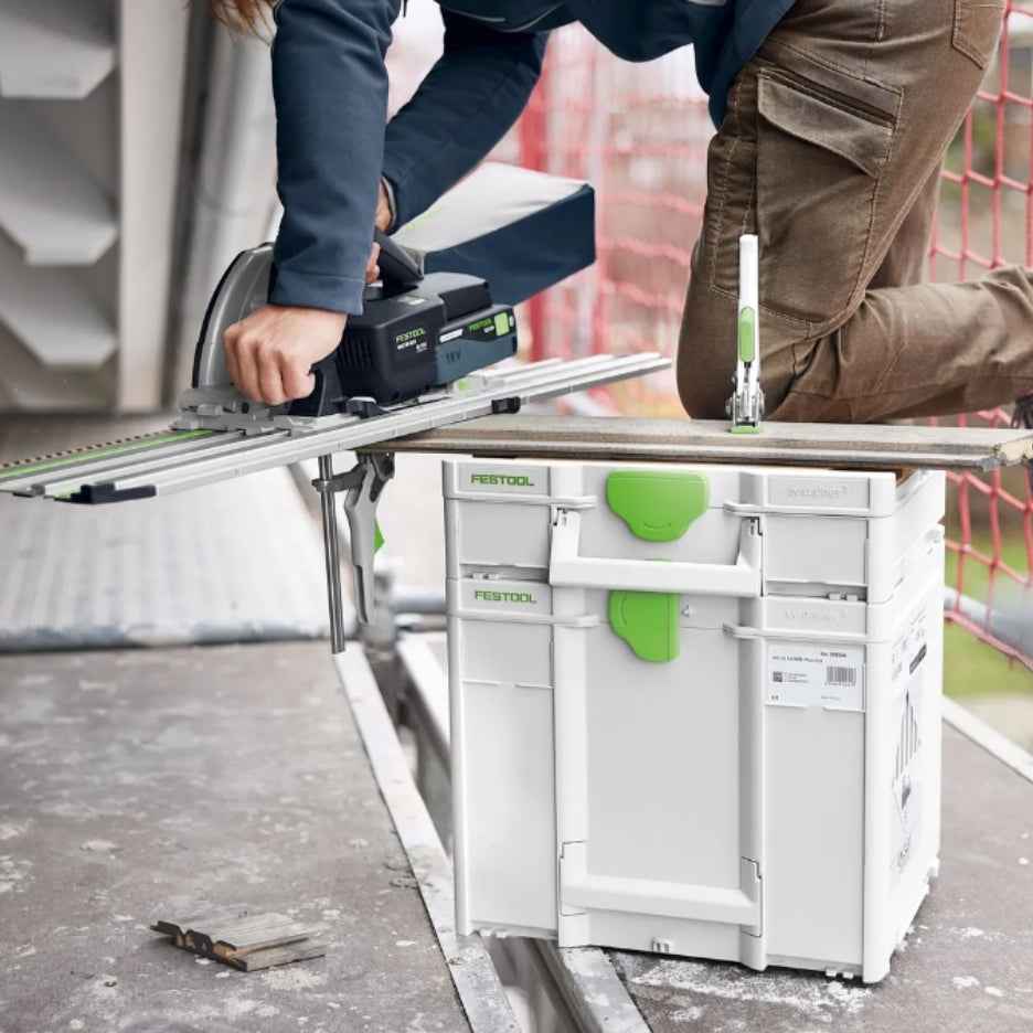Person kneeling on a stack of Systainers, and using a track saw on top