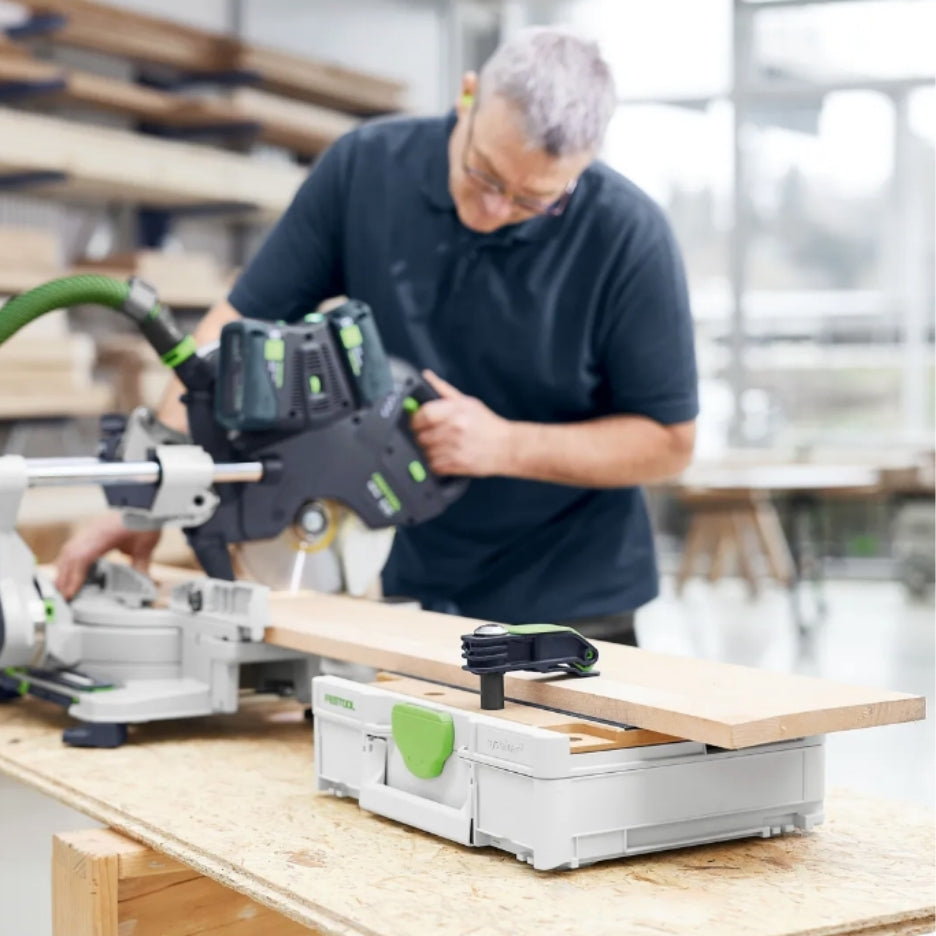 Person using a Festool miter saw in a blured background, with the wood being worked on on top of Festool Systainer SYS3-MFT M 112