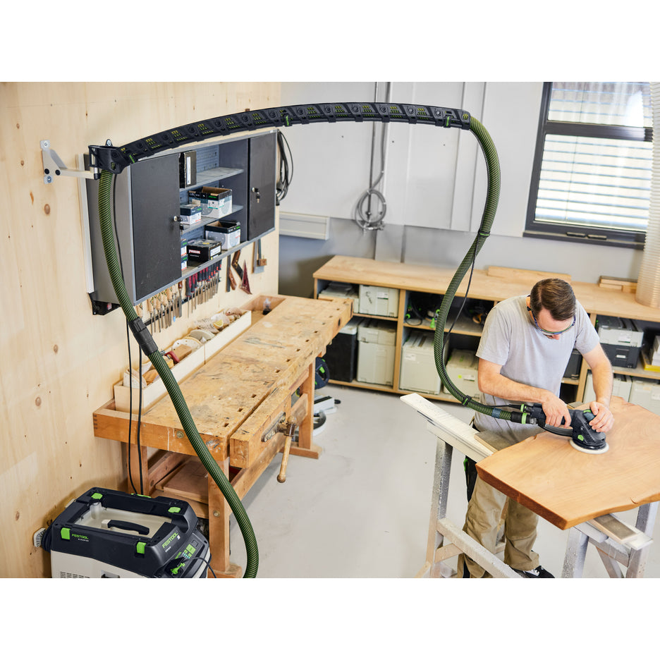 High angle photo of Festool Wall-Mount boom arm set holding hose up above the workpiece while man sands