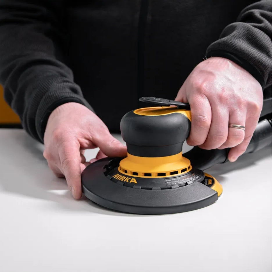 Person attaching Mirka Edge Protector to DEROS sander