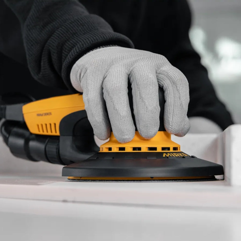 Hand holding DEROS sander with Edge protector attached