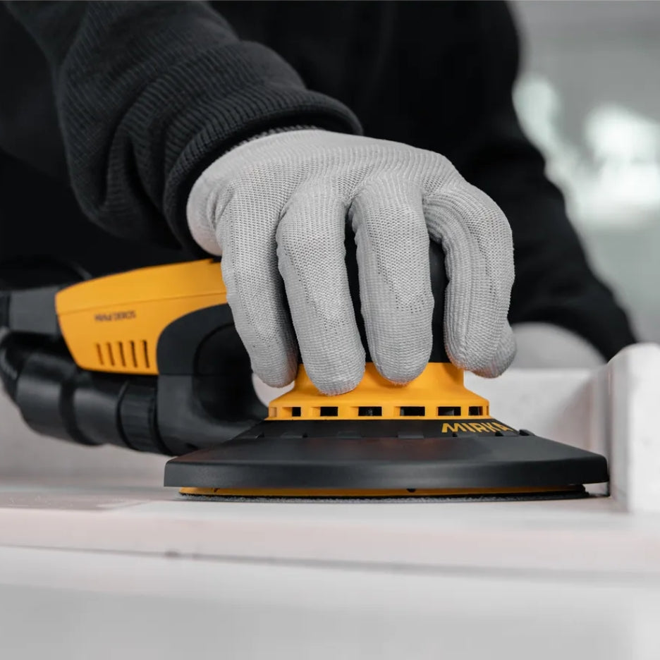 Hand holding DEROS sander with Edge protector attached