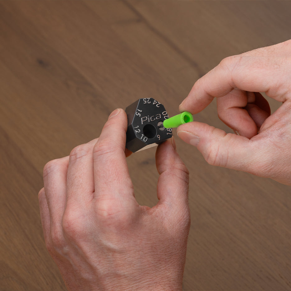 Hands insert a bushing into Scriber Block.