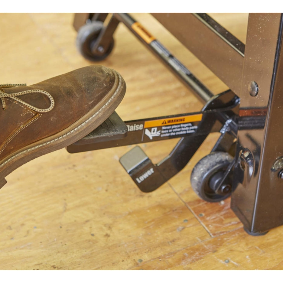 Foot stepping on "raise" lever at SawStop Contractor Saw 's steel base