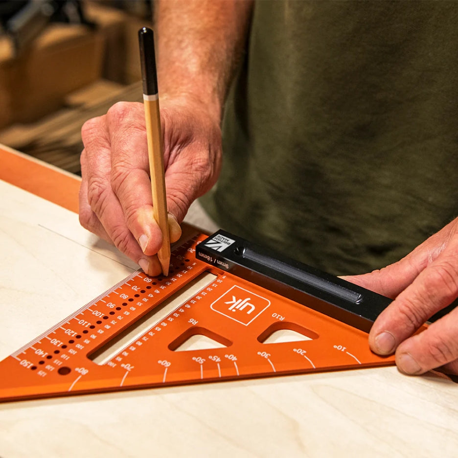 Person using UJK Tools Professional Woodworker's Marking Square and pencil on a wooden surface