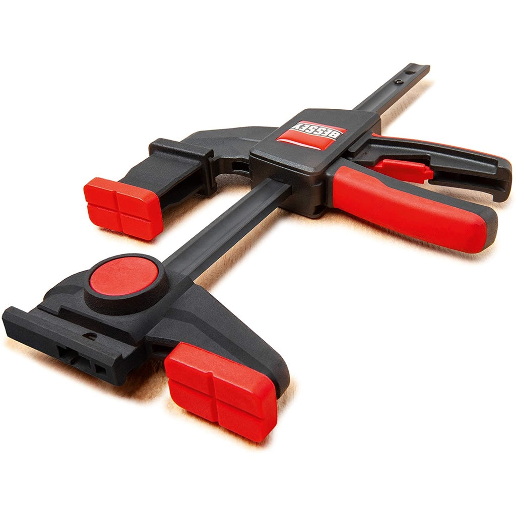 Detail view of a Bessey EZR clamp showing T-slot profile, cross grooves on clamping pads, 2" stepover attachment, trigger.