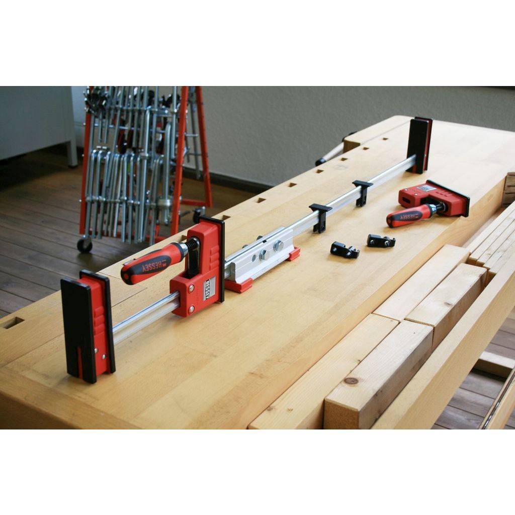 Bessey Clamp Extender attached to two bar clamps to make a longer one