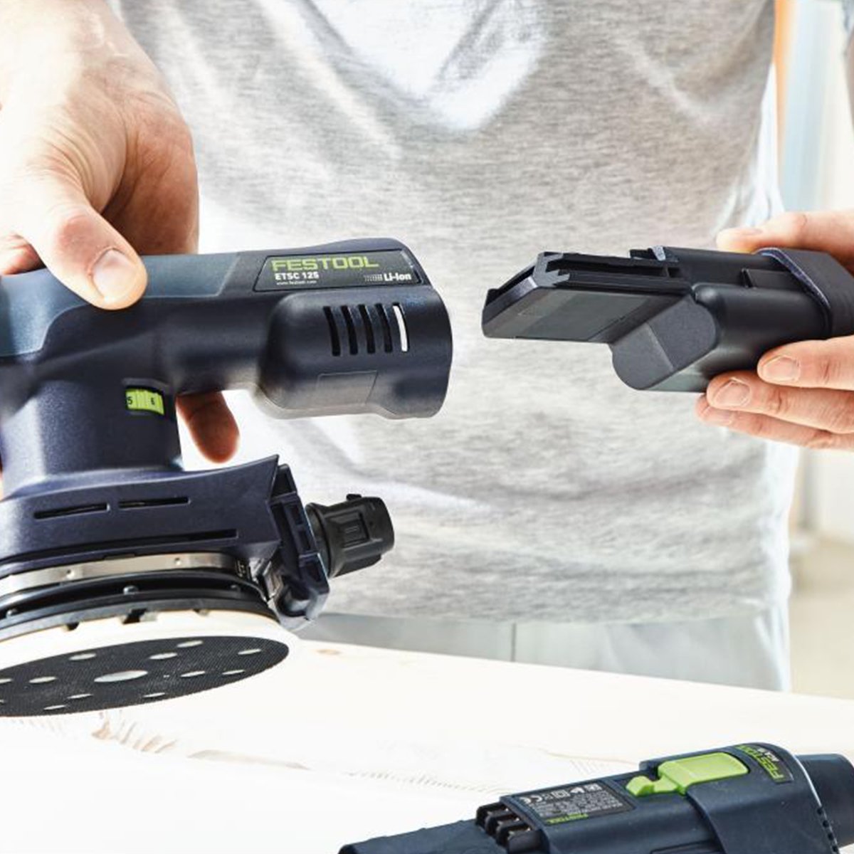 An operator has removed one battery and is installing a freshly charged Ergo battery into the back of the ETSC 125.