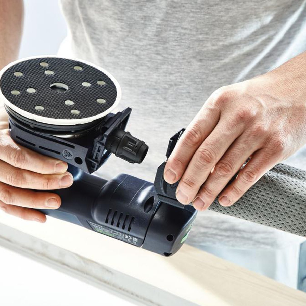 An operator has an Ergo battery installed and is attaching the reusable longlife dust collection bag.