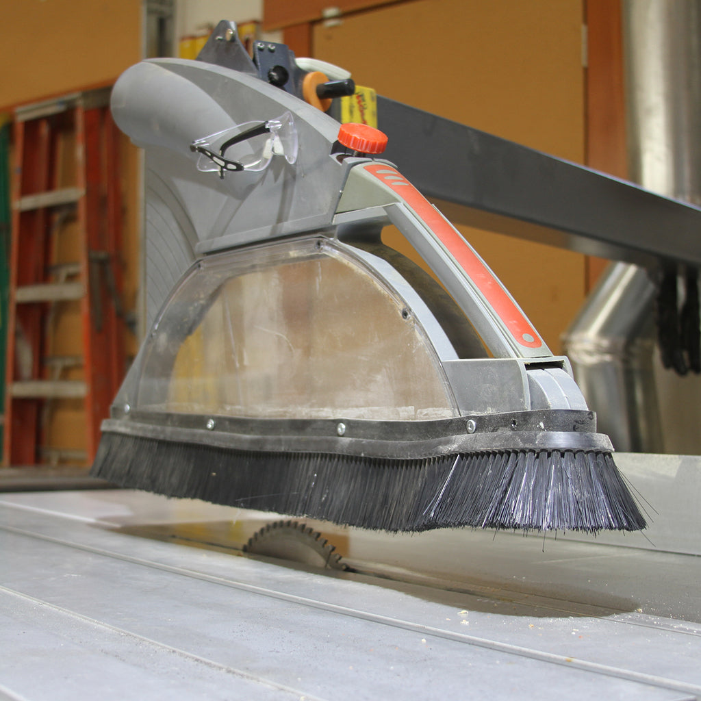 Saw Stache riveted to the overhead blade guard of a sliding table saw to focus vacuum suction around the blade.