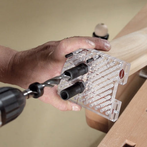 Man holds Lamello Rasto Duo jig on the end of a handrail while drilling for Invis Mx2 hardware with drill bit & bushing.