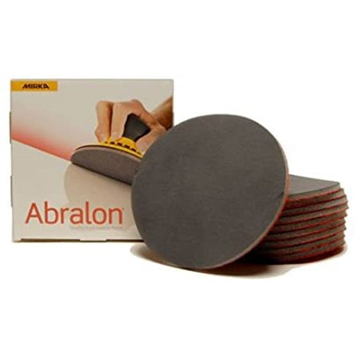A stack of Mirka Abralon 6" soft flexible foam-backed silicon carbide abrasive sanding discs with cardboard box.