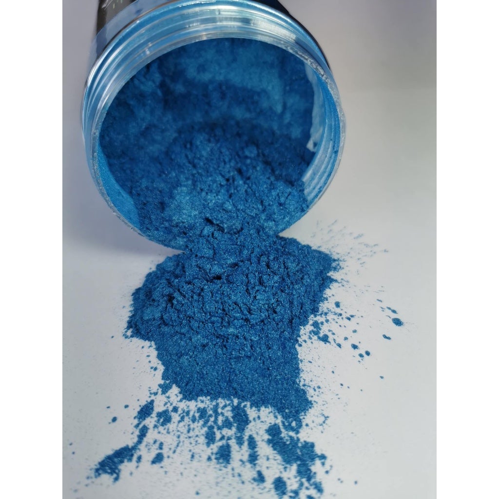 A jar of Aruba Blue Ryver Epoxy Aurora Metallic Pigment on its side showing the actual colour and consistency of mica.