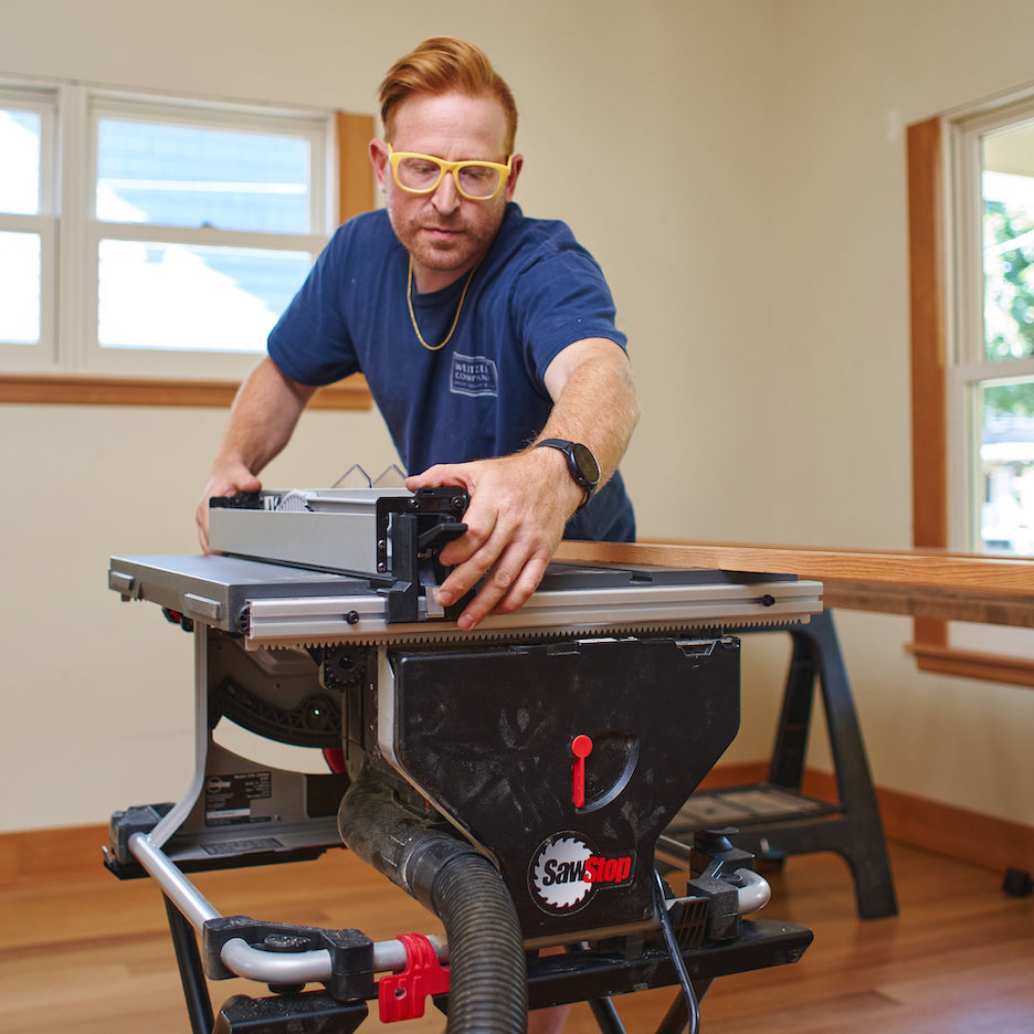 Man puts fence on SawStop Compact Table Saw.