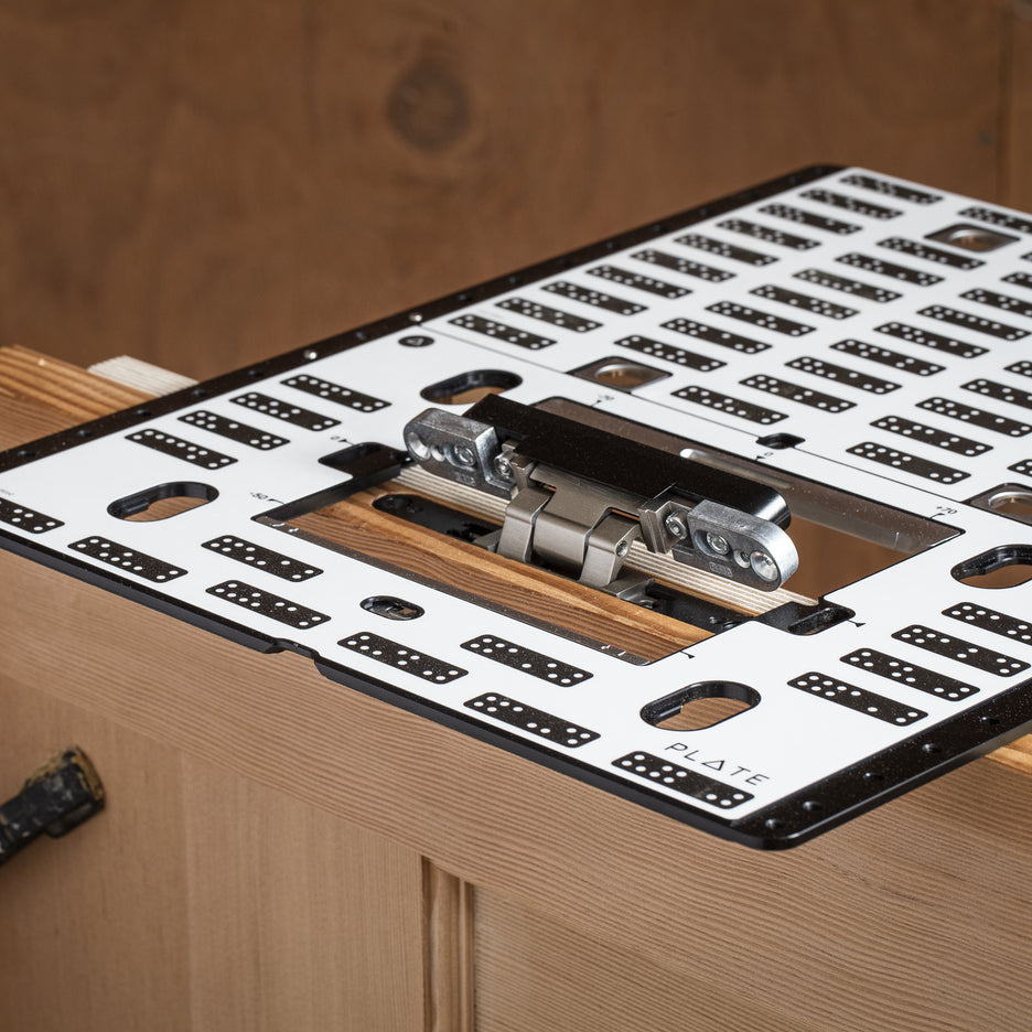 Shaper plate clamped to a wooden door to cut recess for hinge, installed.